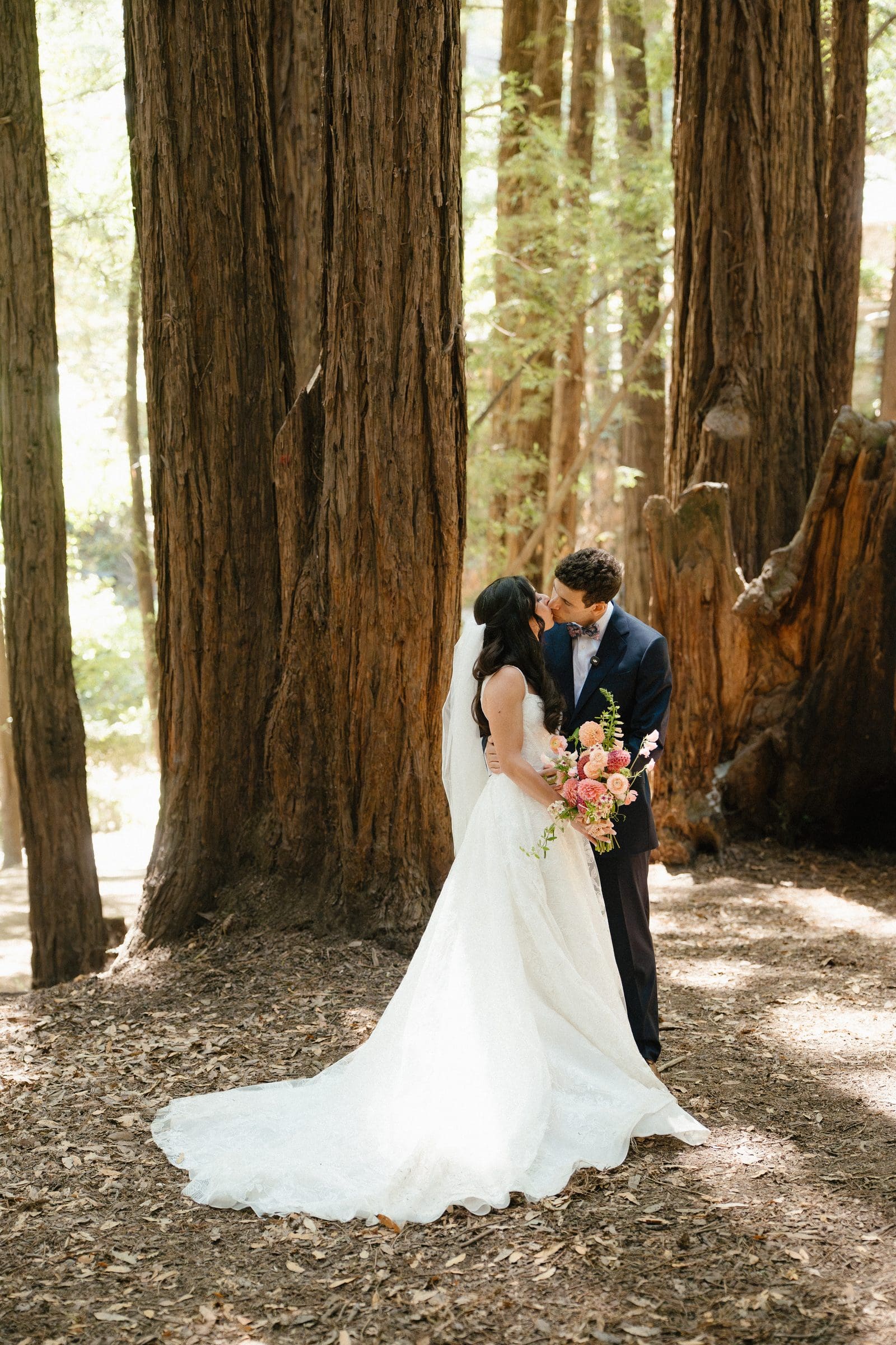 Adam and Lala embracing beneath the redwoods