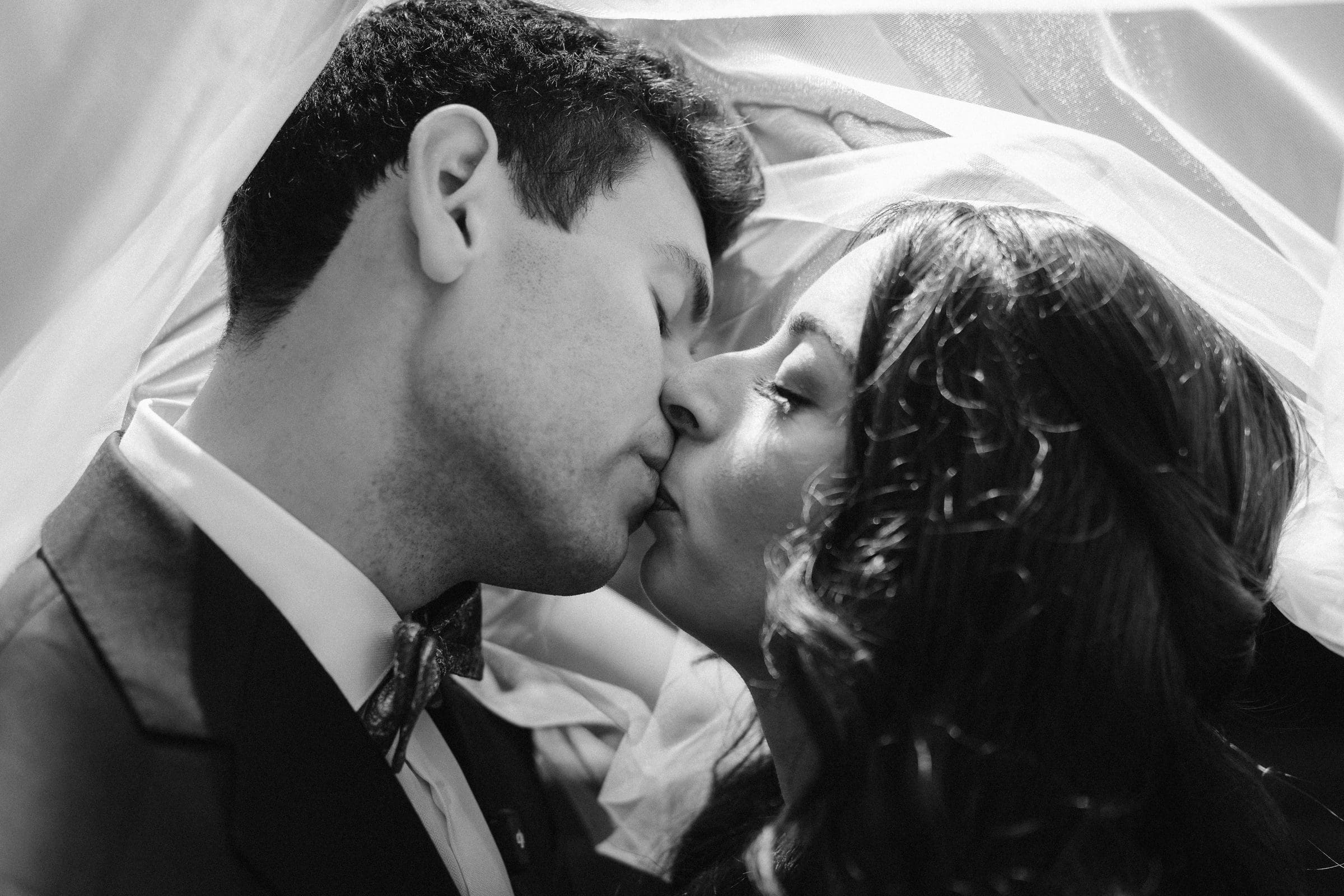 Adam and Lala kissing under her veil, black and white