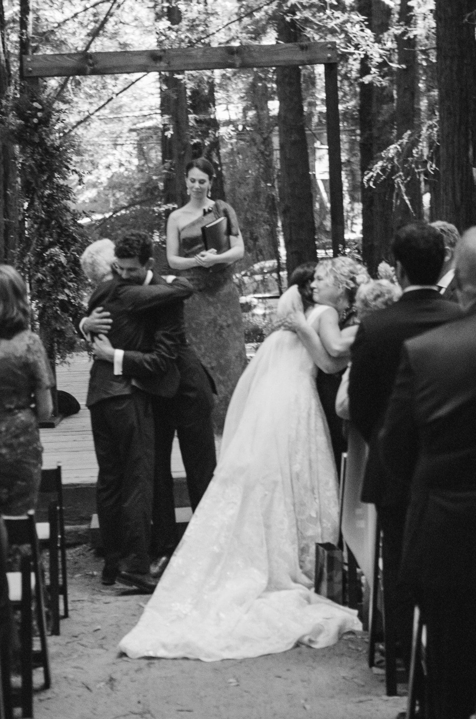Hugs at the front of the ceremony, black and white film
