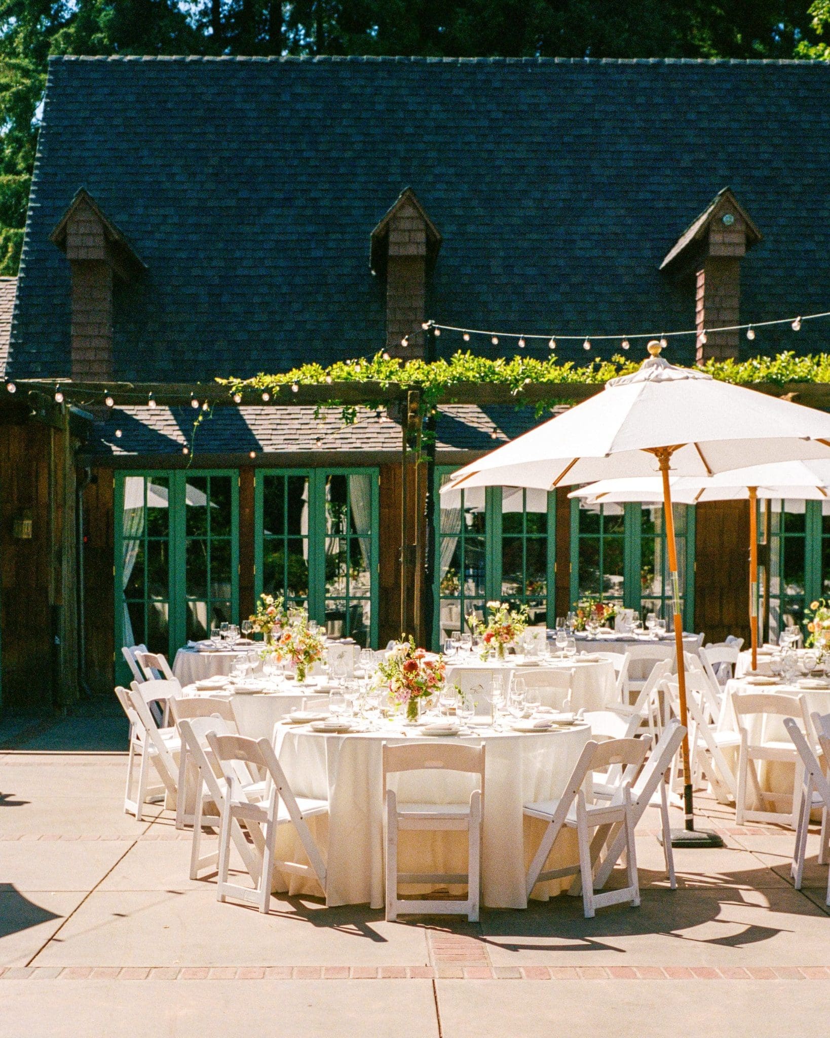 Reception tables under white umbrellas at the Outdoor Art Club, on film