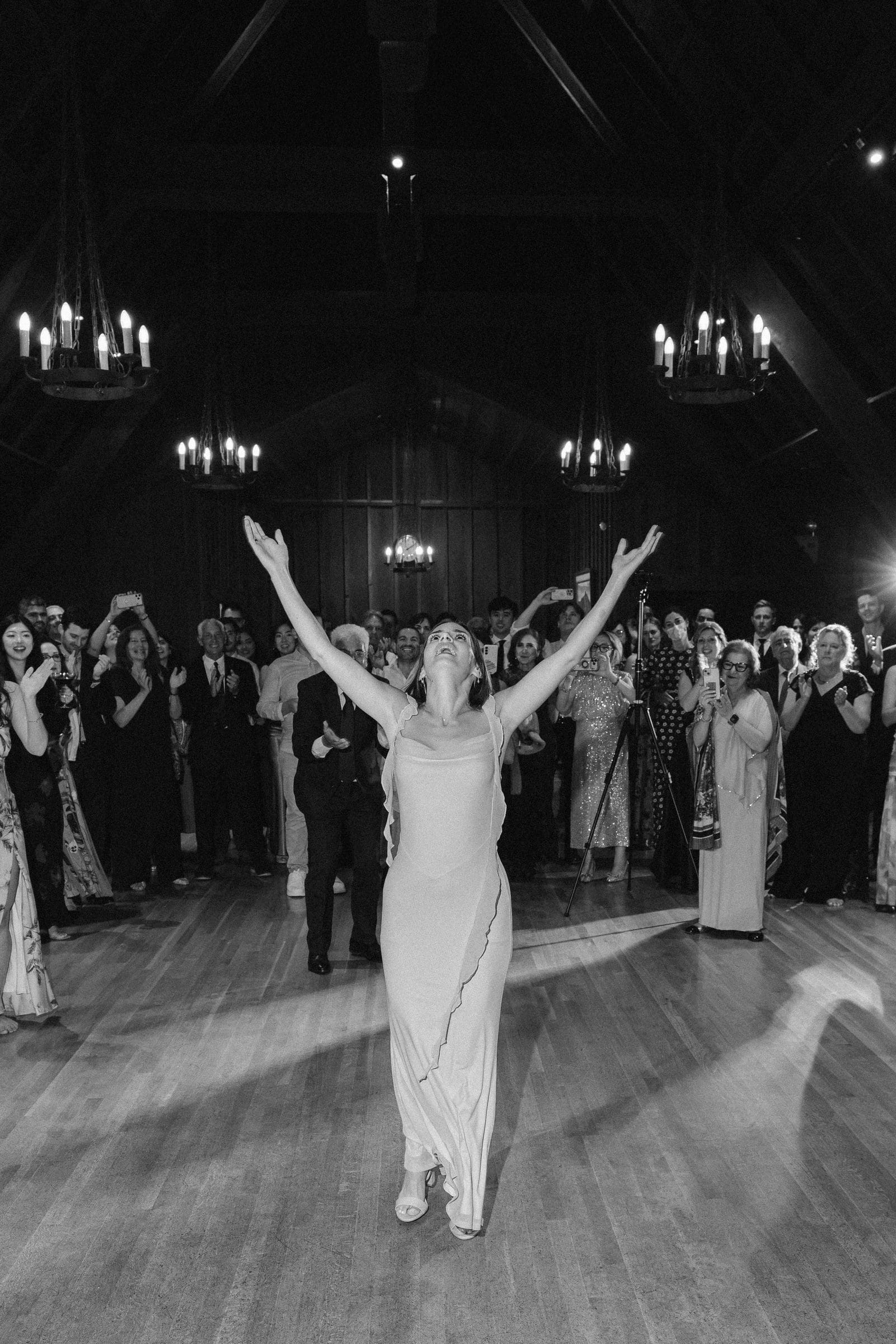Lala raising her arms on the dance floor, black and white