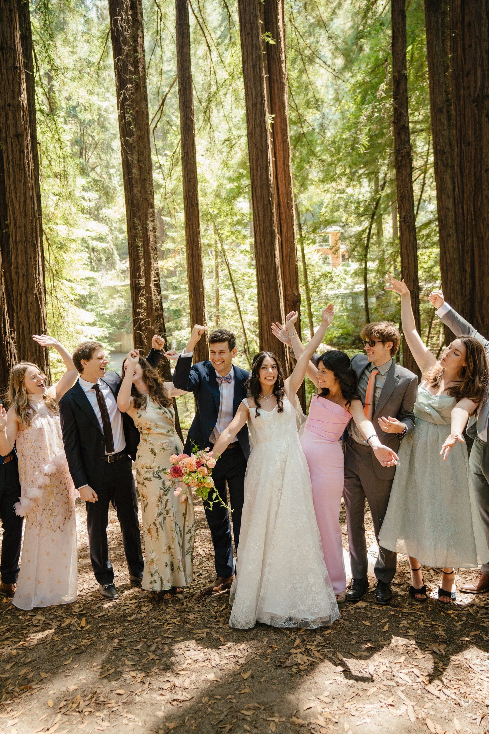 Lala and Adam celebrating with their wedding party in the redwoods