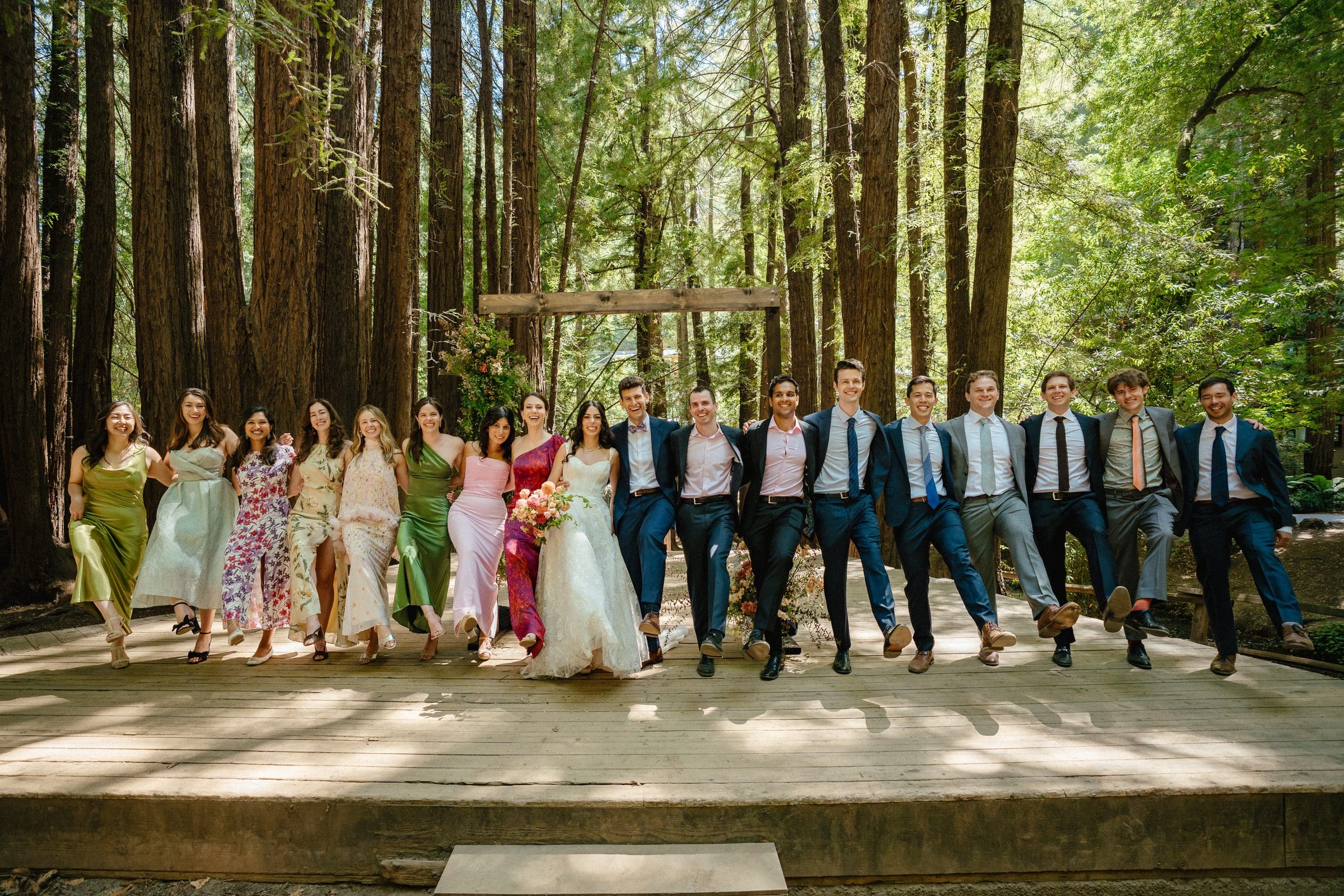 Adam and Lala with their wedding party on the redwood stage