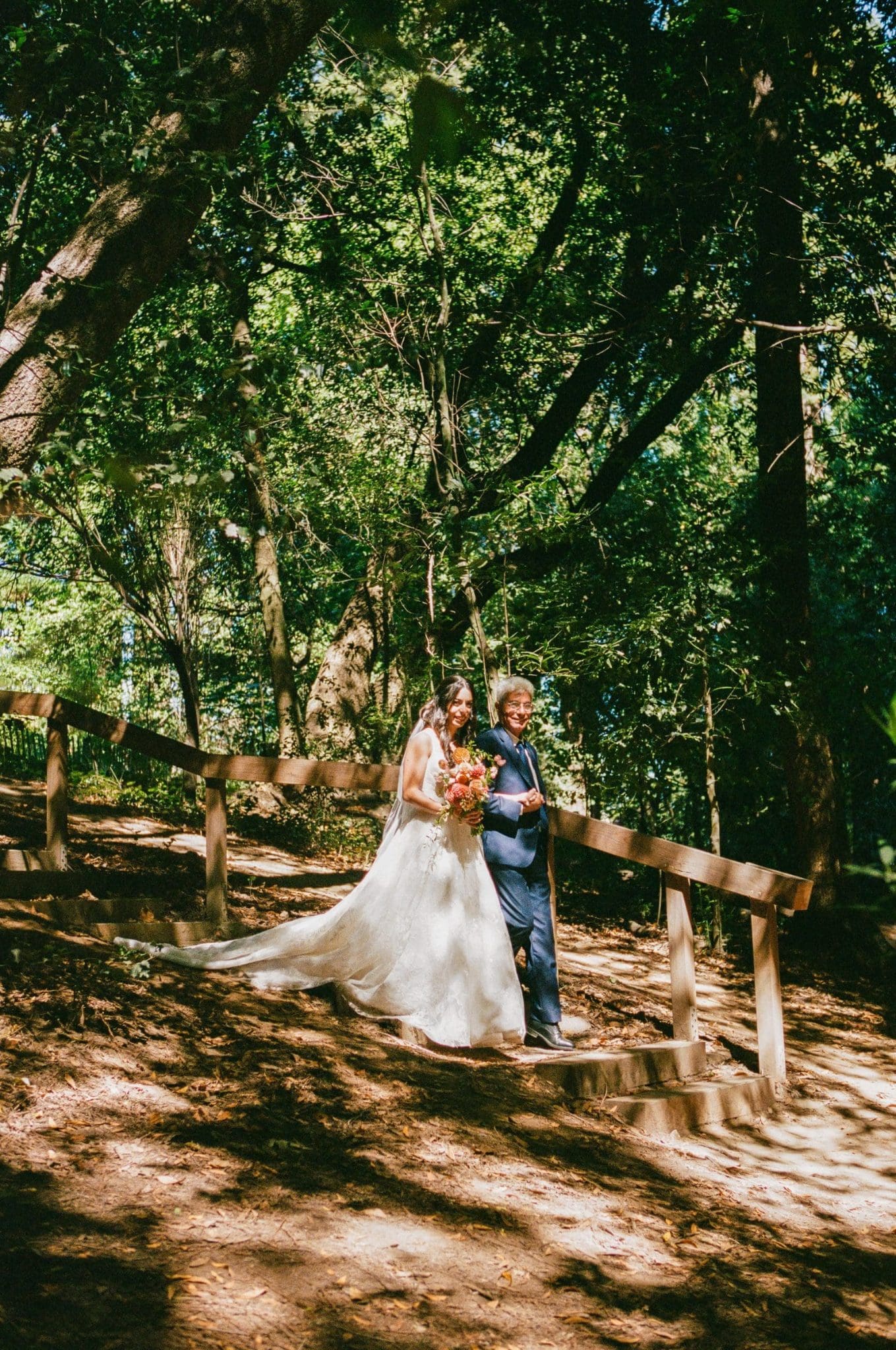 Lala walking toward the ceremony through the redwoods, on film