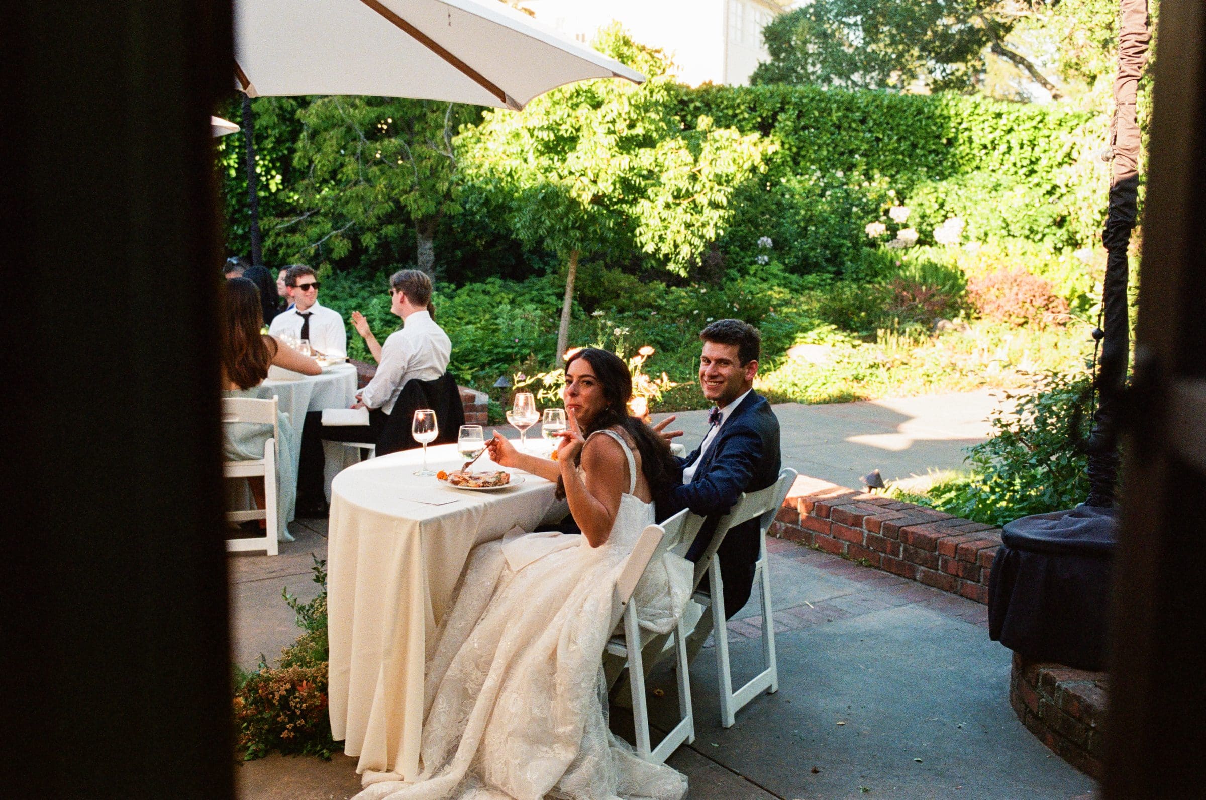 Adam and Lala at their table on the patio, on film