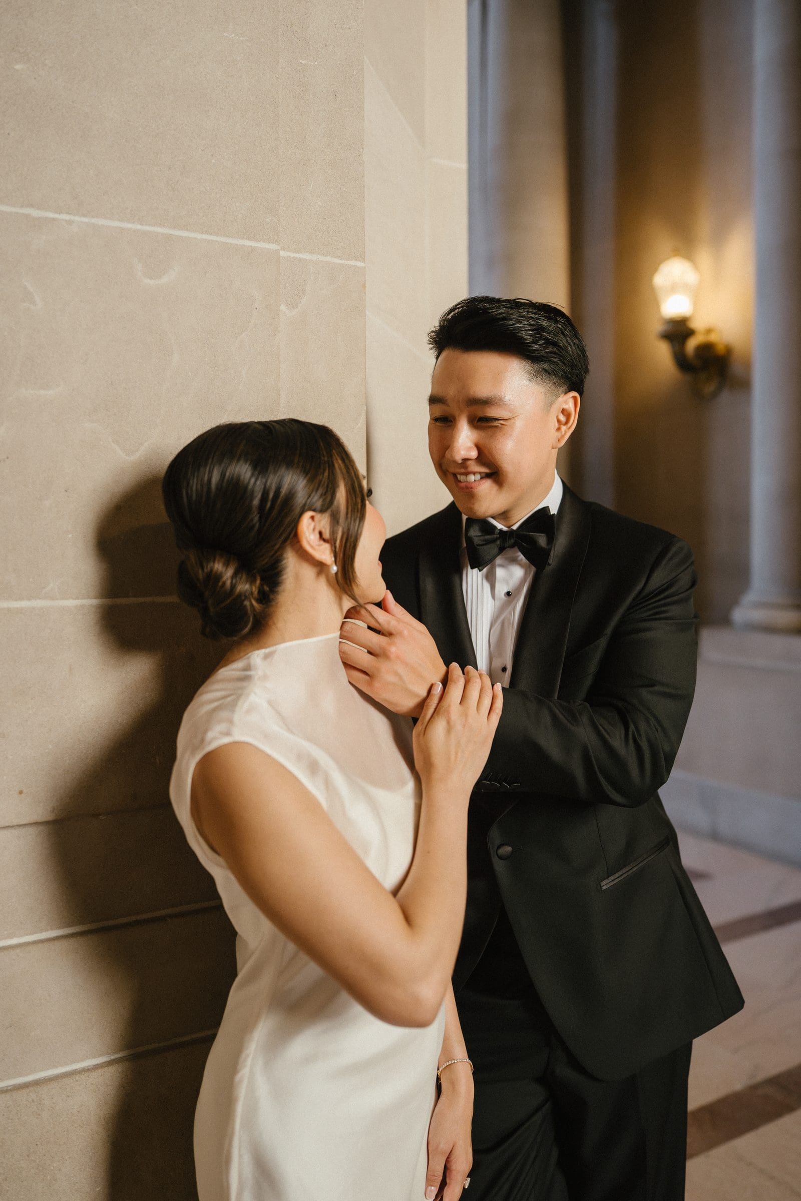 Michelle reaching for David against a marble wall at City Hall