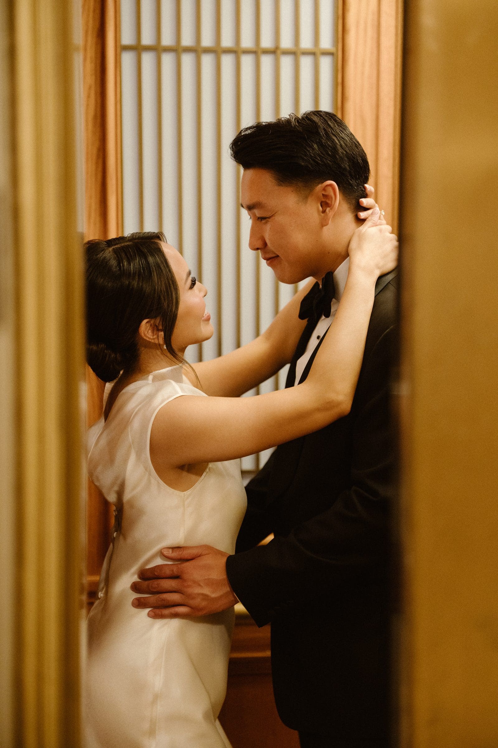 Michelle holding David close against the gold elevator doors