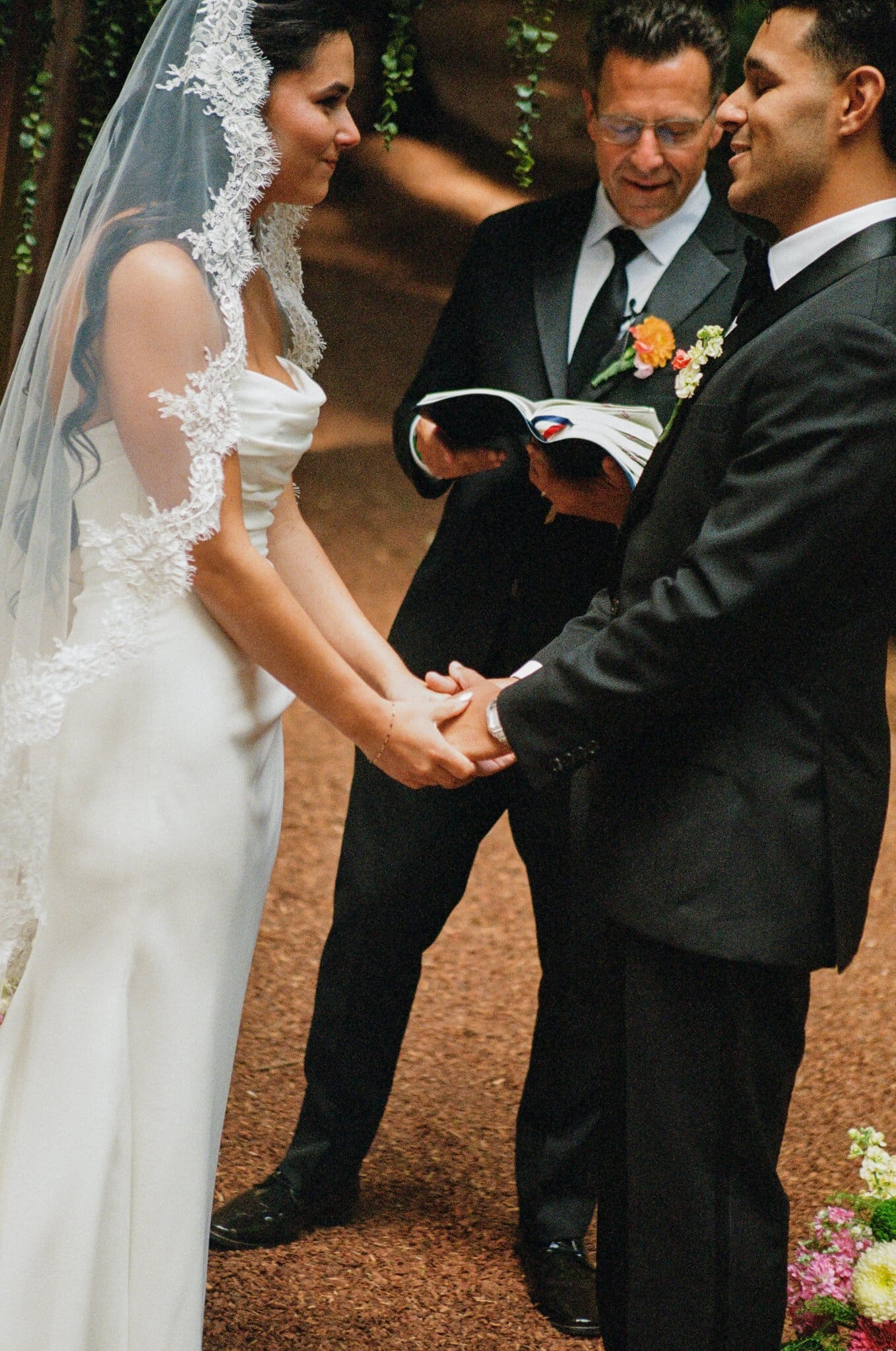 Sofia and Devin holding hands during their vows, on film