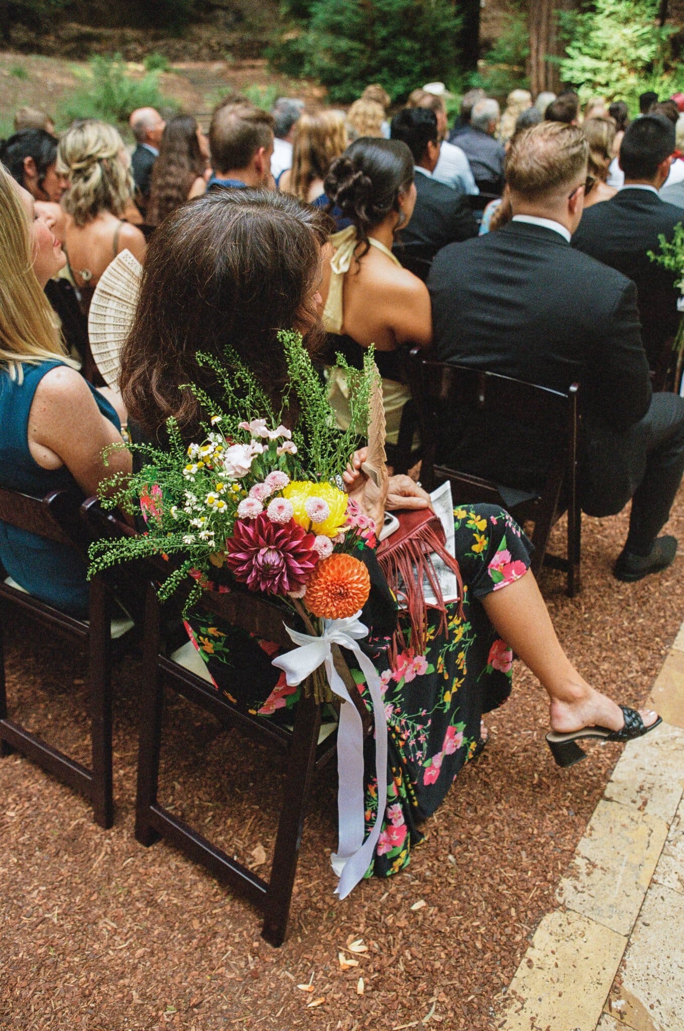 Bright bouquet resting with guests during the redwood ceremony, on film