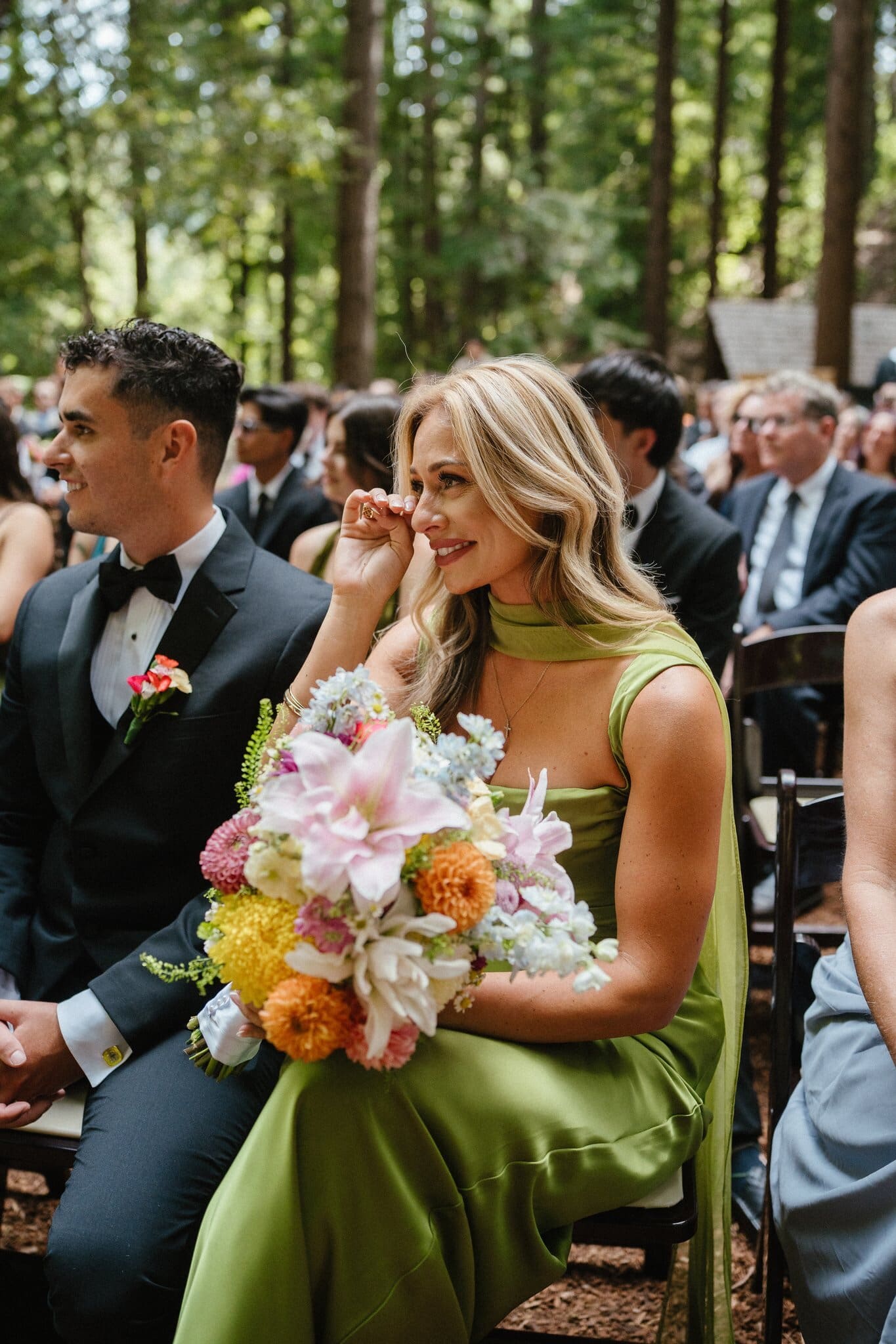 Bridesmaid smiling with her bouquet during the vows