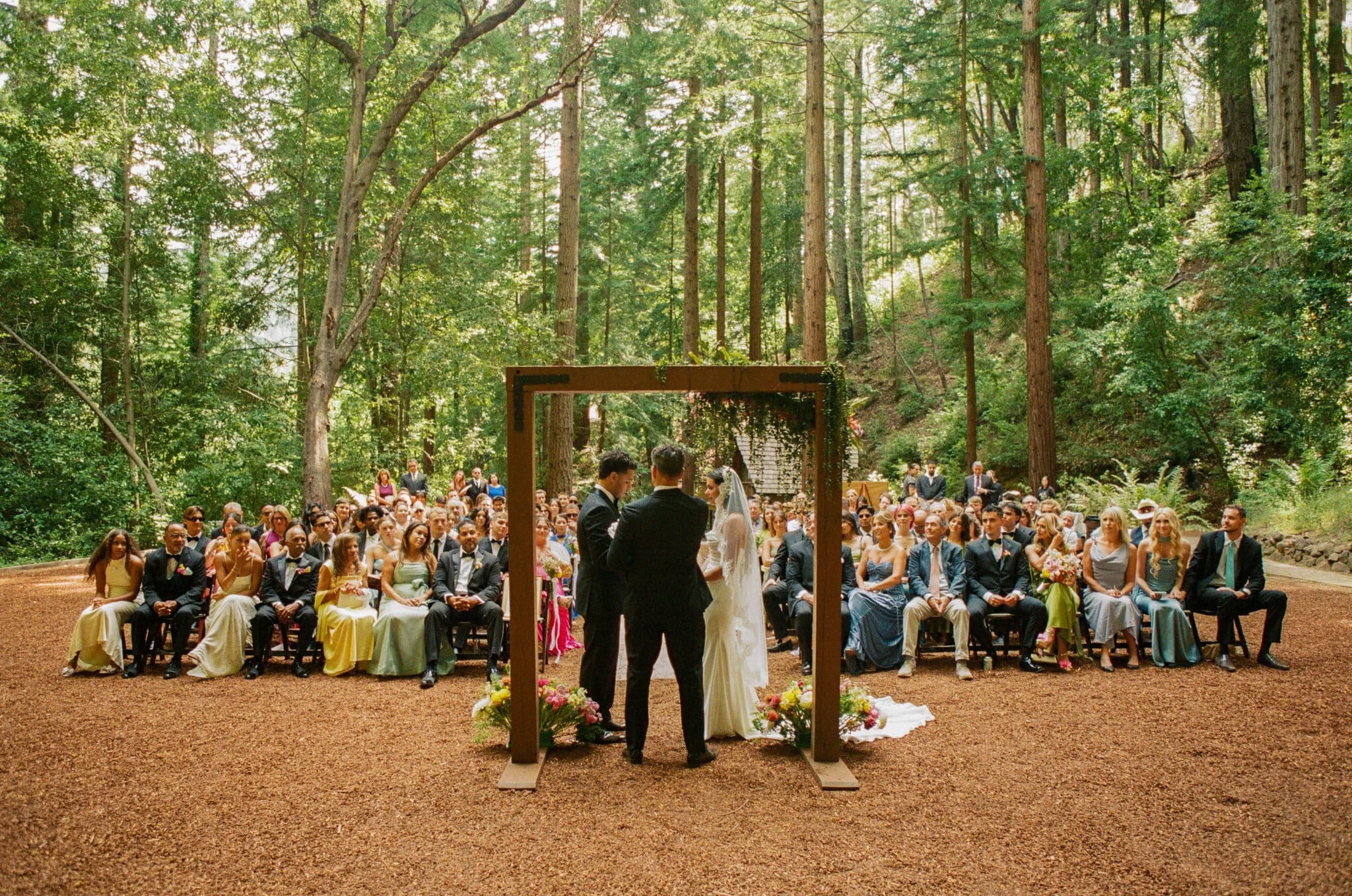 Wide view of the ceremony in the redwood grove at Waterfall Lodge & Retreat, Santa Cruz Mountains, on film