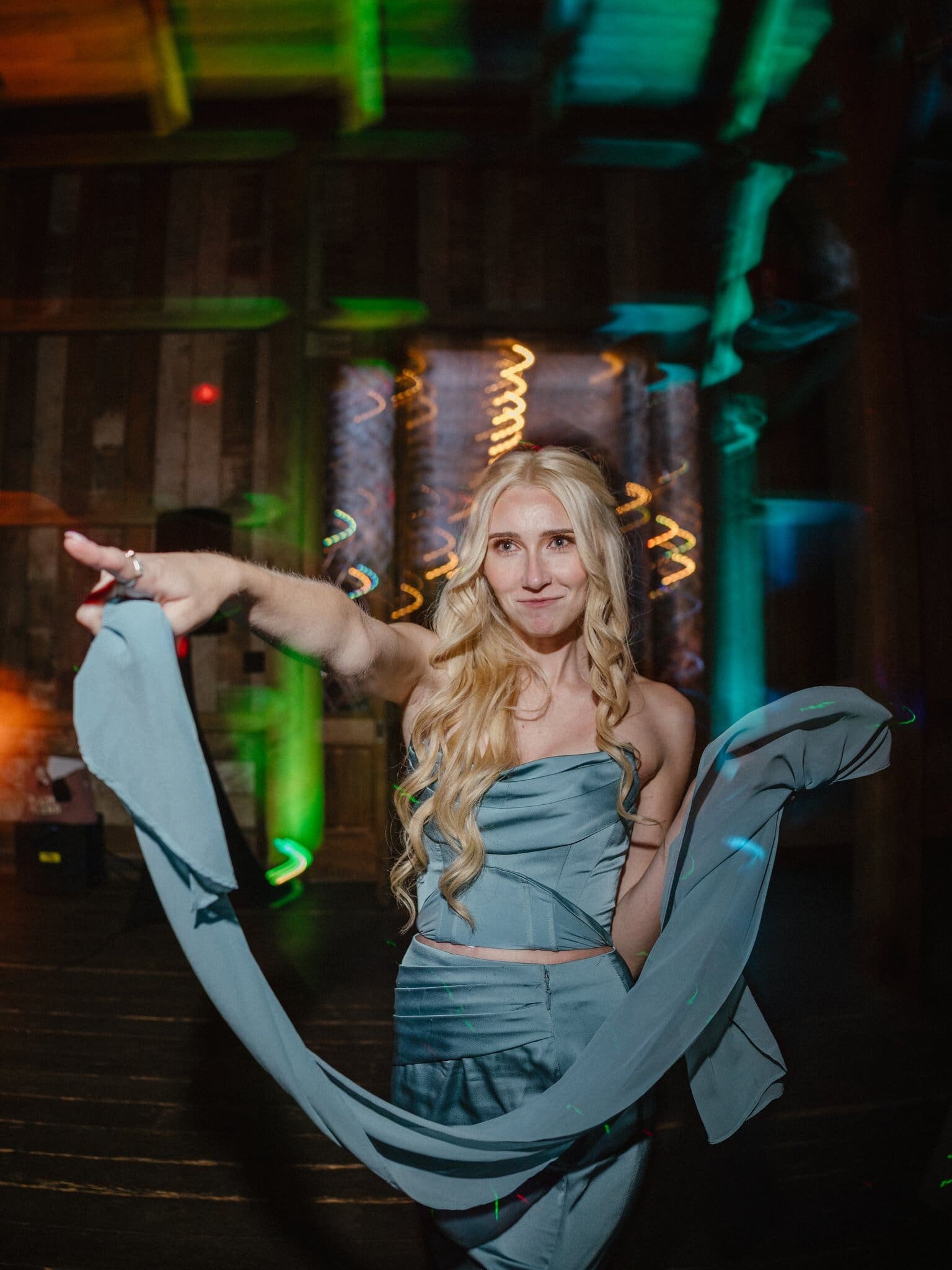 Guest dancing with a scarf under colored lights