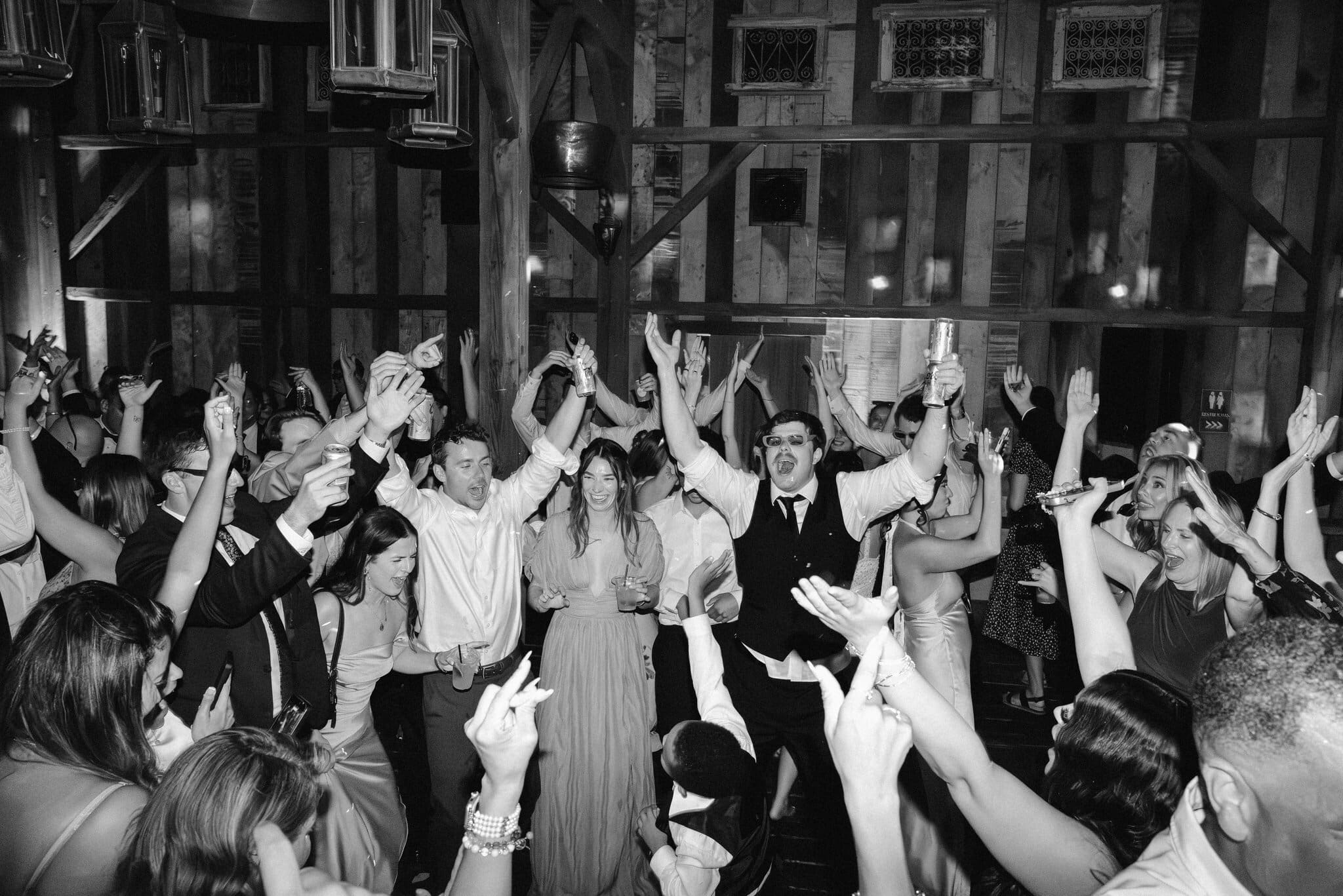 Packed dance floor with hands in the air, black and white