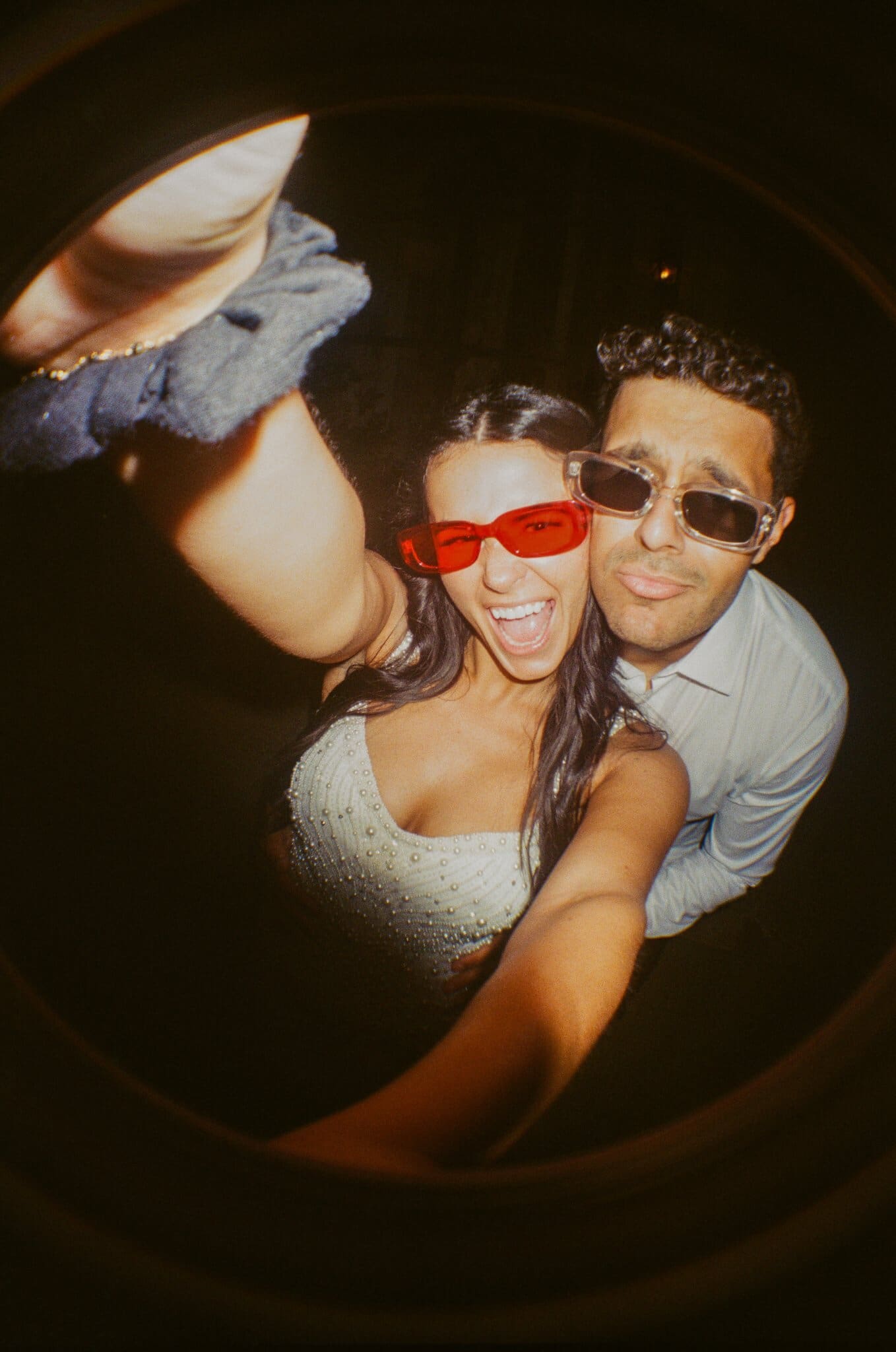 Sofia and Devin in sunglasses on the dance floor, flash on film
