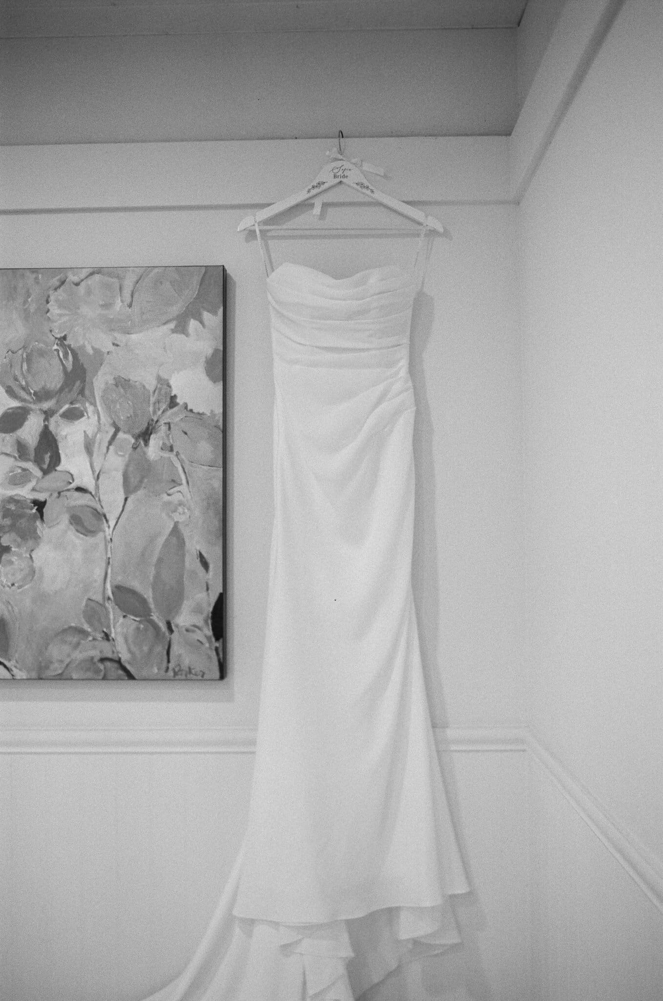 Wedding dress hanging in the bridal suite at Waterfall Lodge & Retreat, black and white film