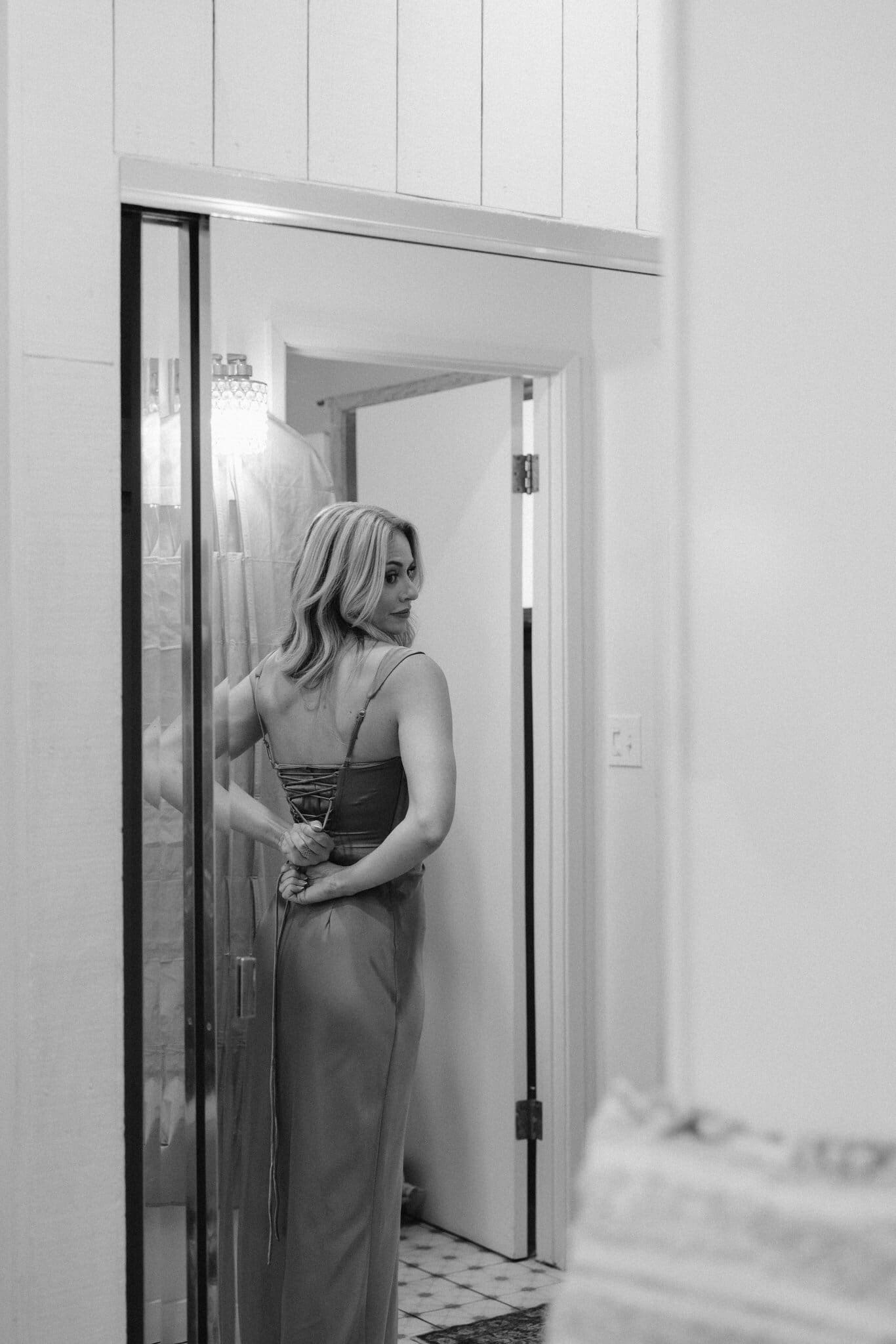 Bridesmaid in the bridal suite doorway, black and white