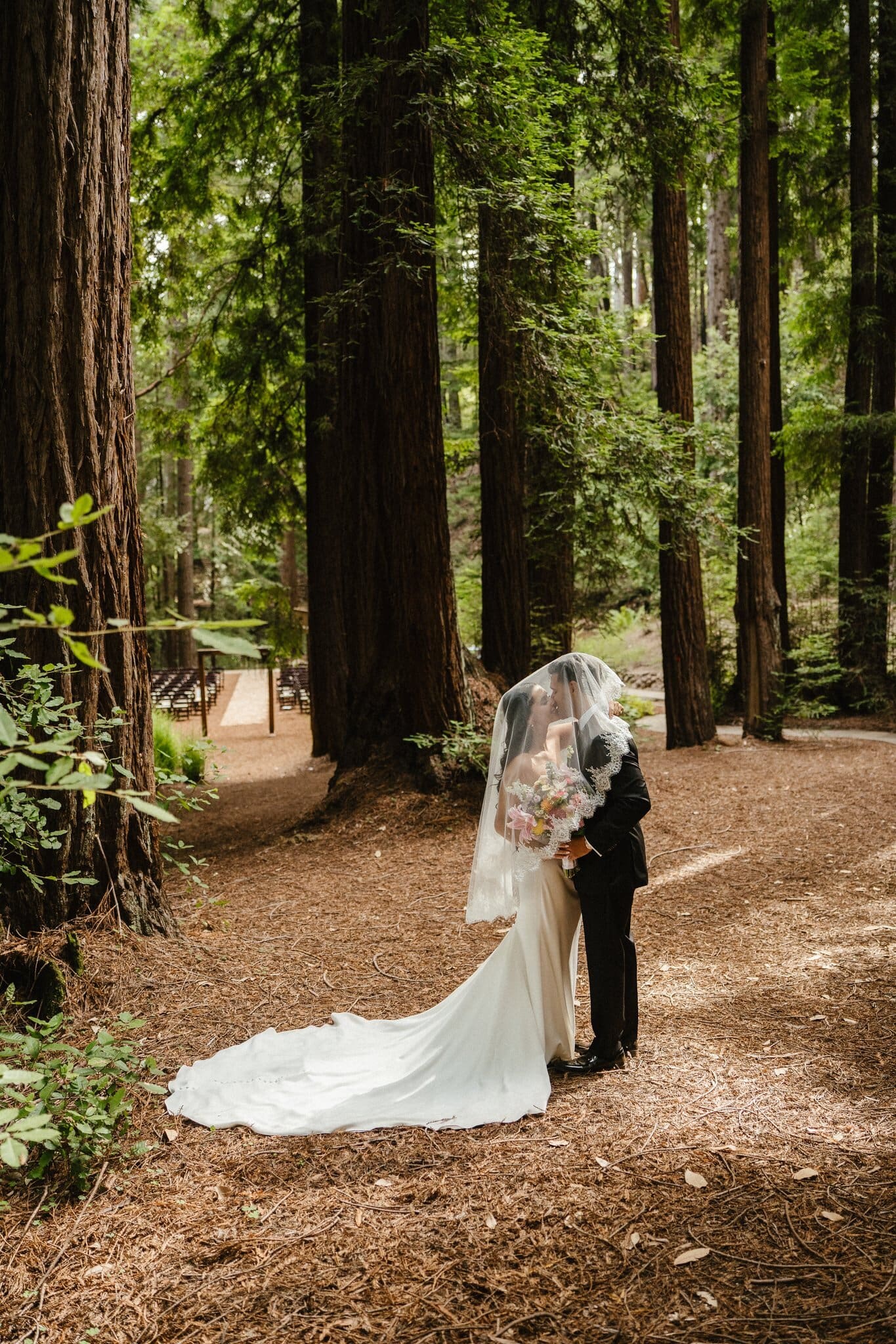 Sofia and Devin under her veil in the redwood forest