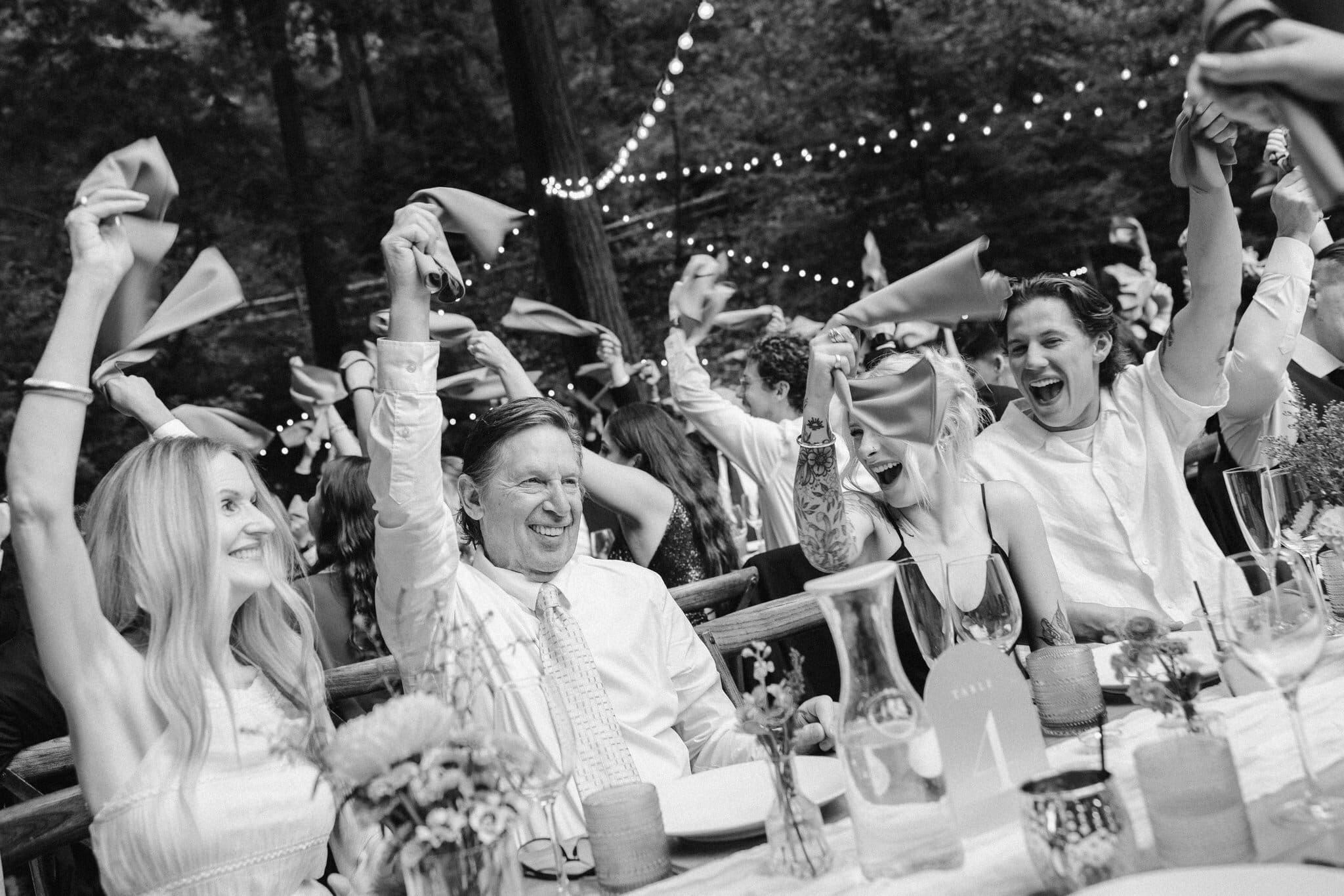 Guests waving napkins during the grand entrance, black and white