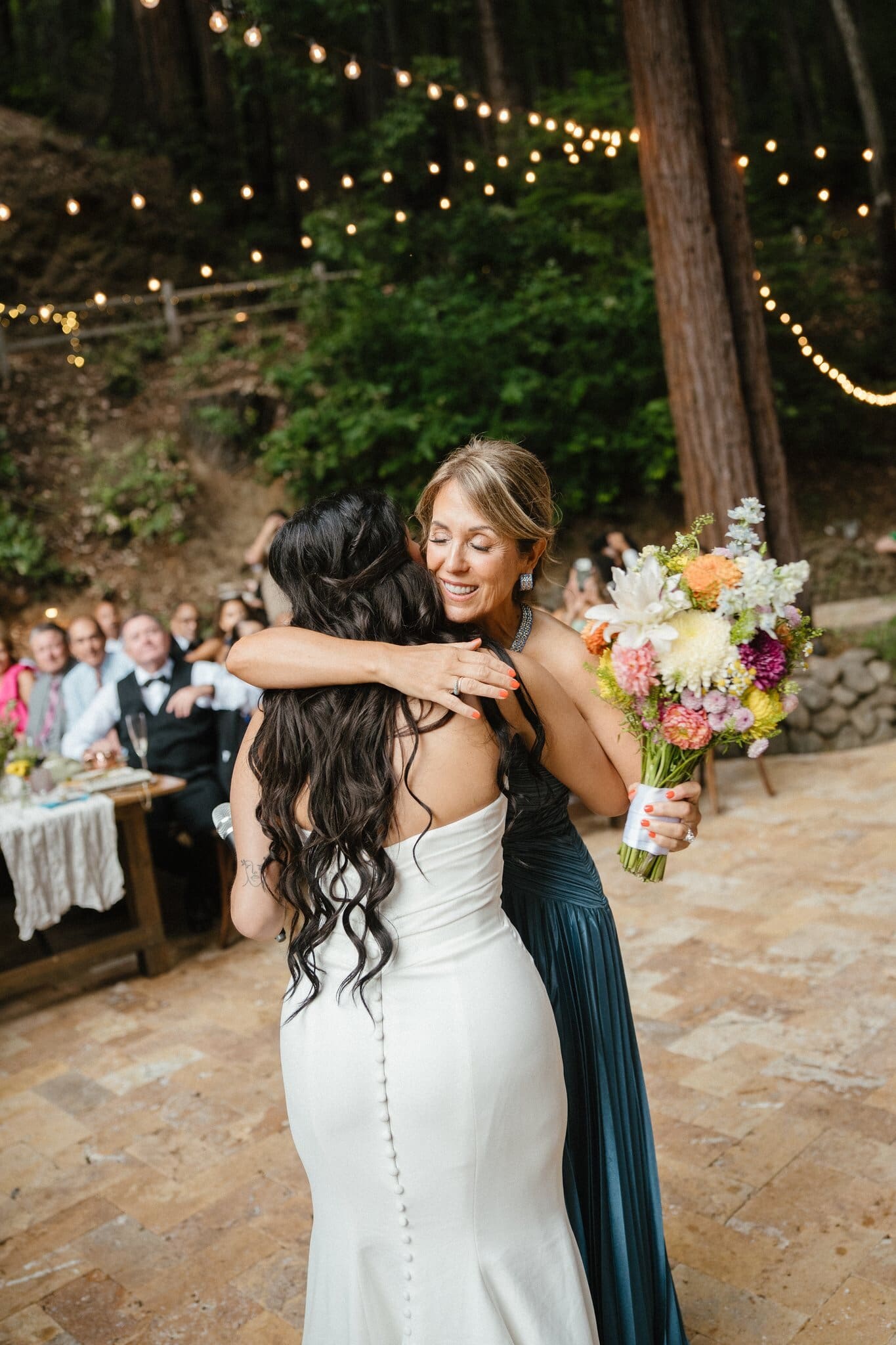 Sofia embracing a bridesmaid at the reception