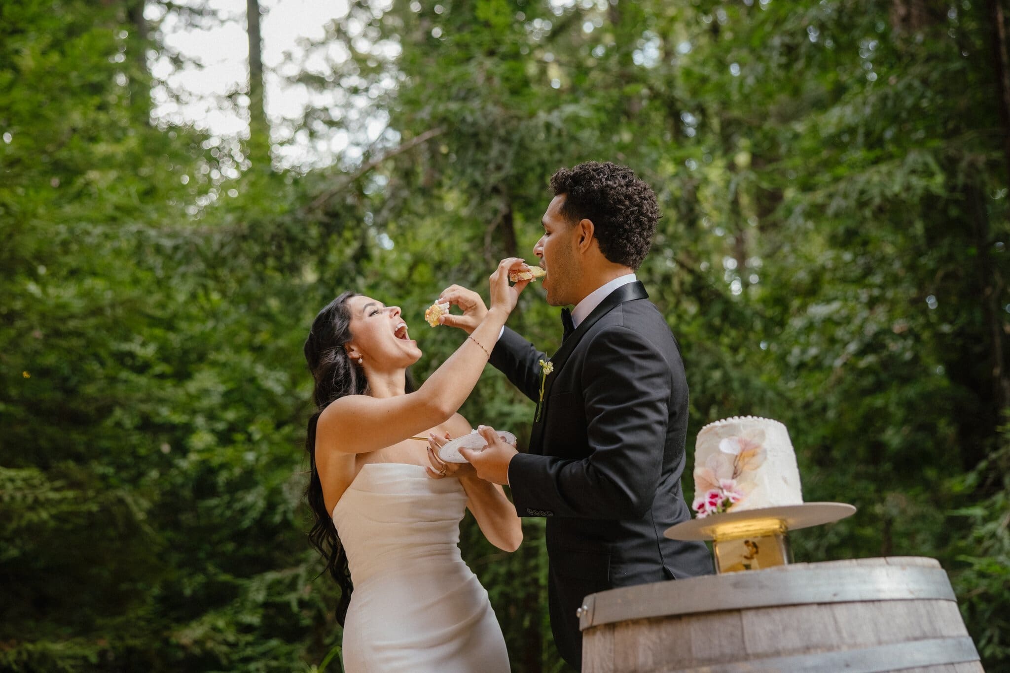 Sofia and Devin feeding each other cake in the redwoods