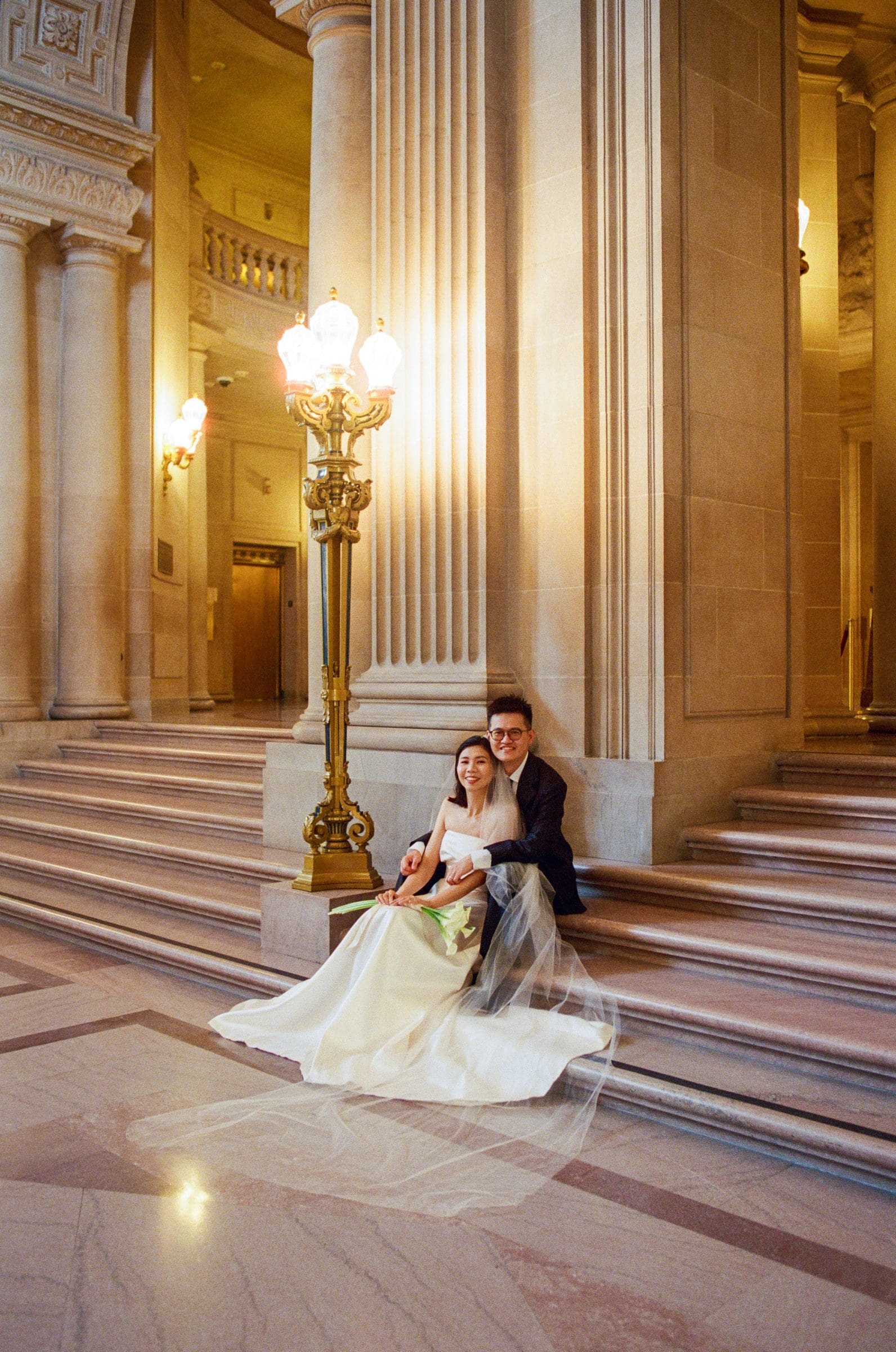 Ting and Hsiang sitting on the marble steps at San Francisco City Hall, on film