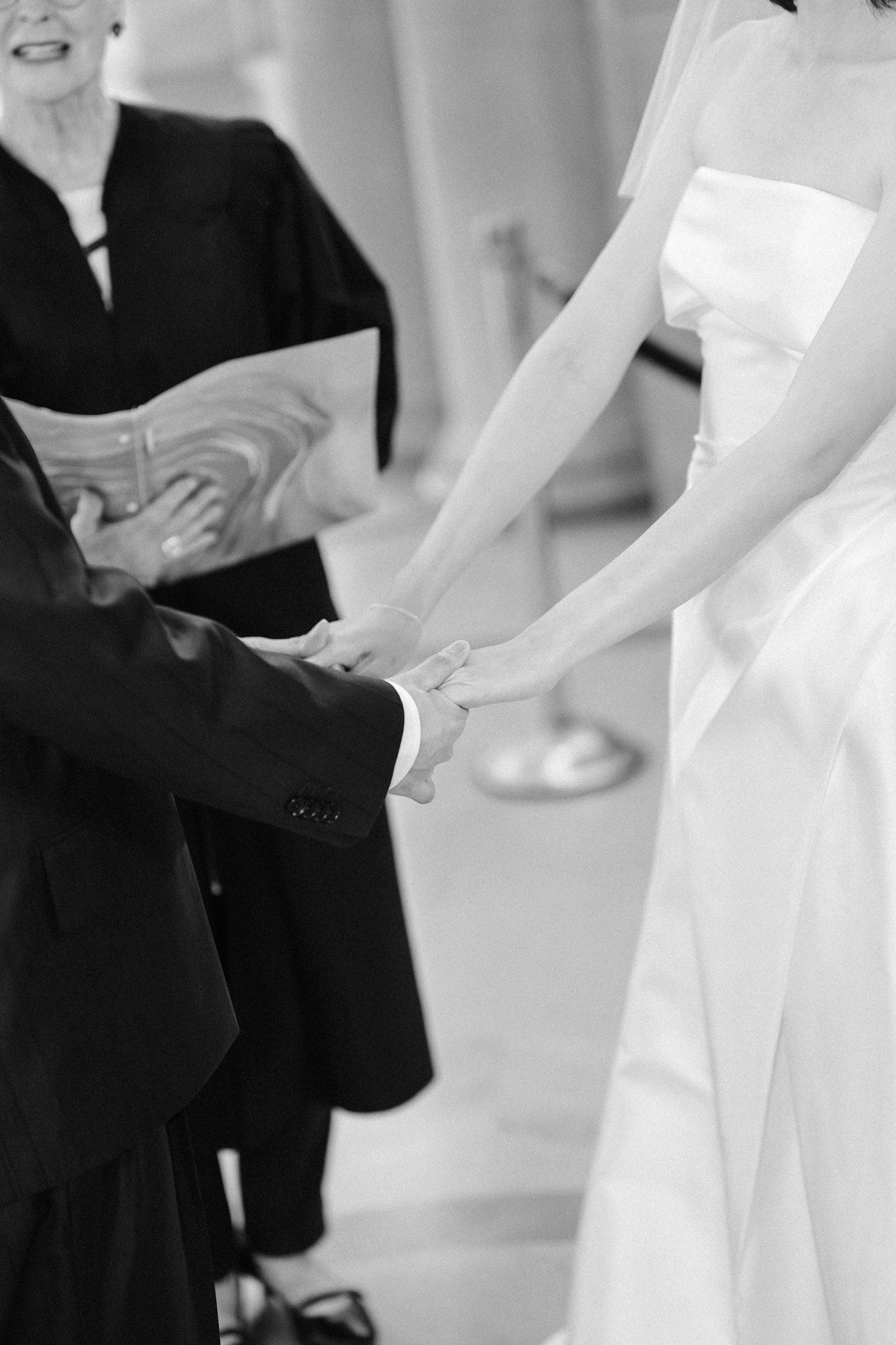 Holding hands during the ceremony, black and white