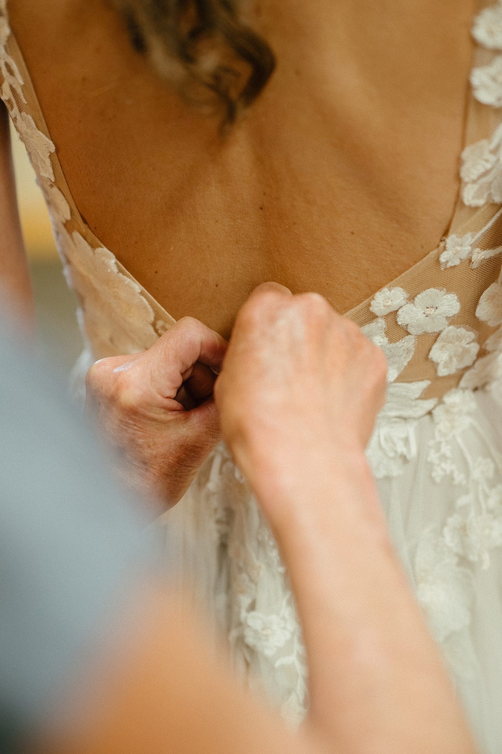 Buttoning the back of Isabelle's lace wedding dress