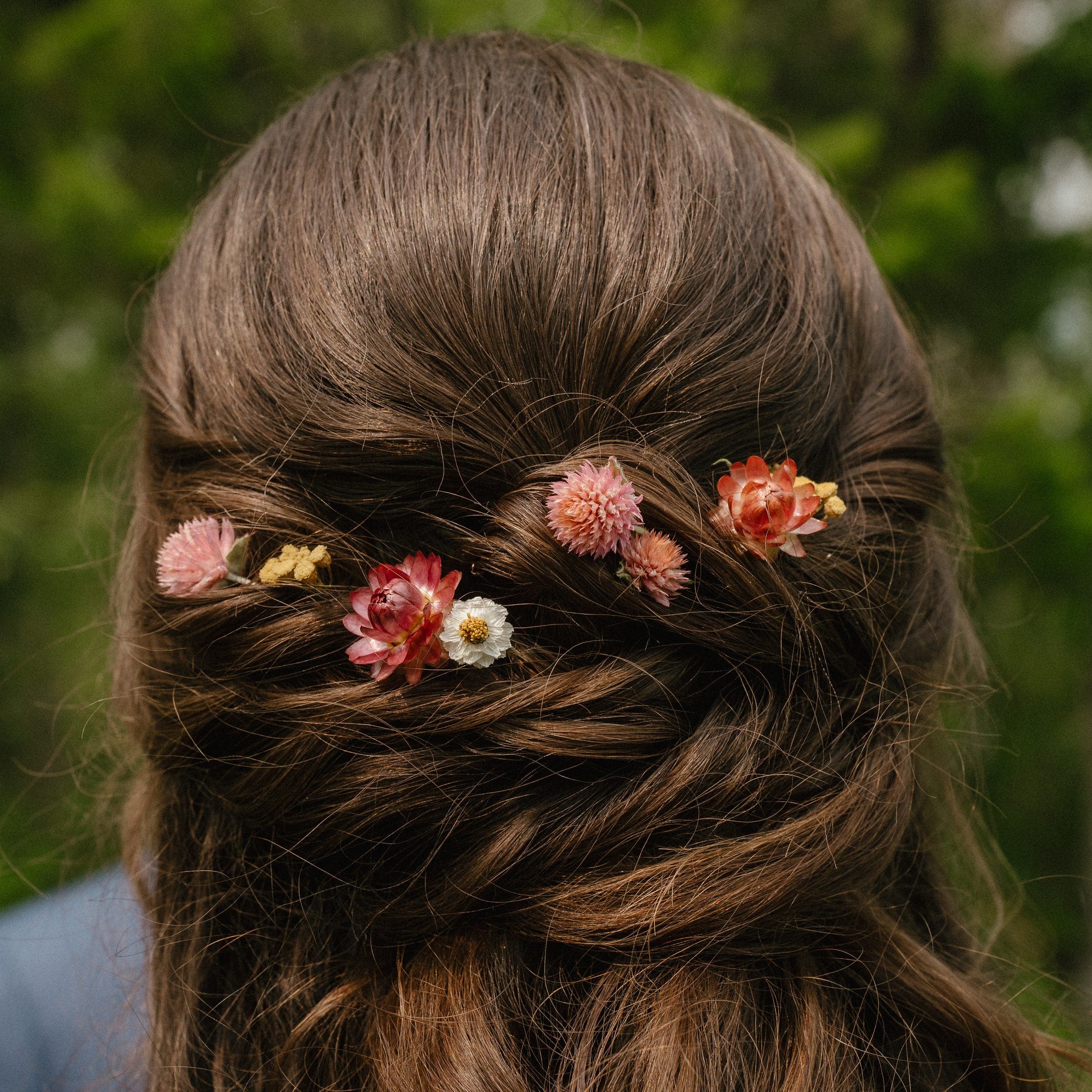 Dried flowers tucked into Isabelle's braided bridal hair