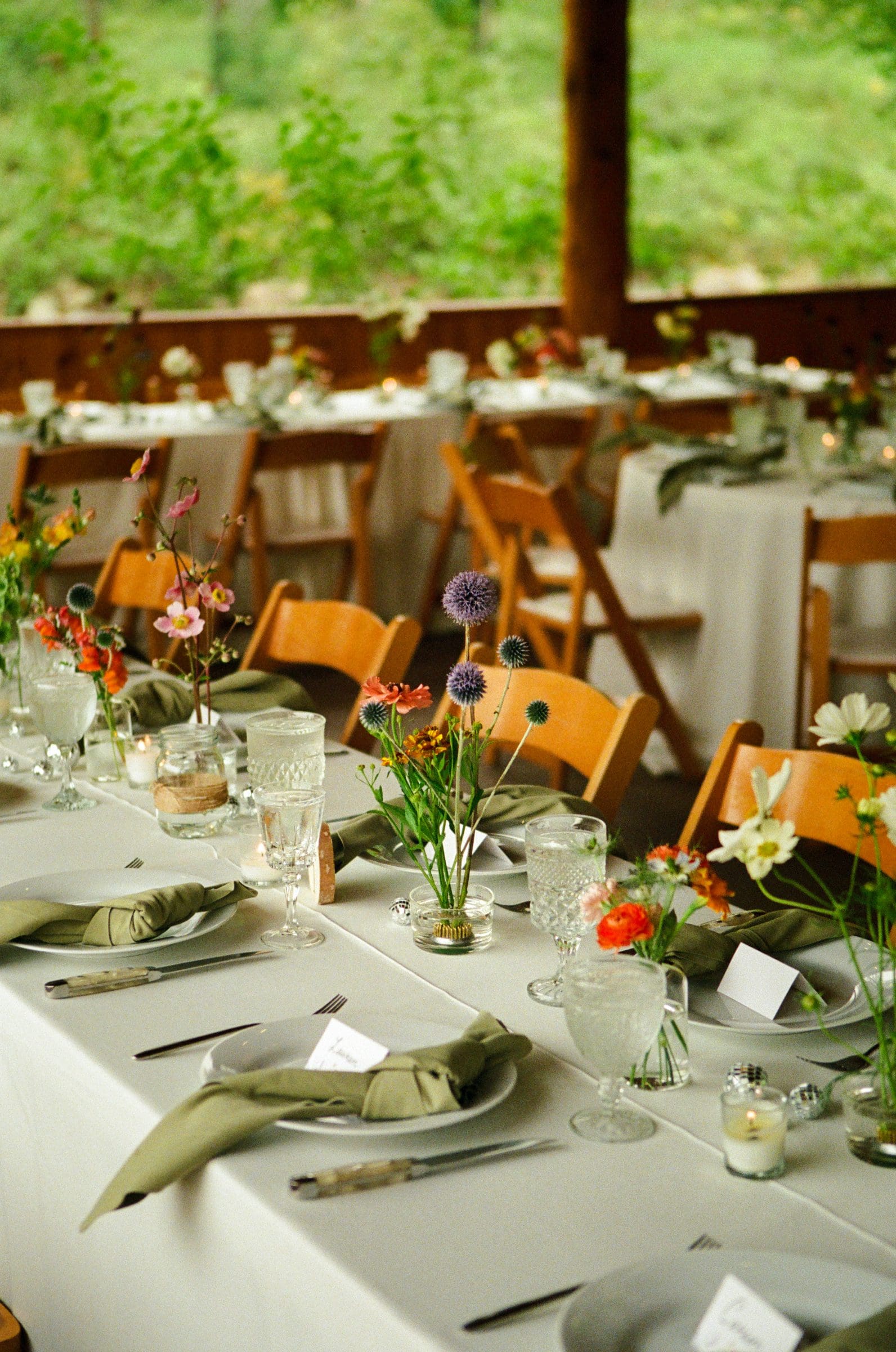 Reception tables with wildflowers inside the timber pavilion, on film
