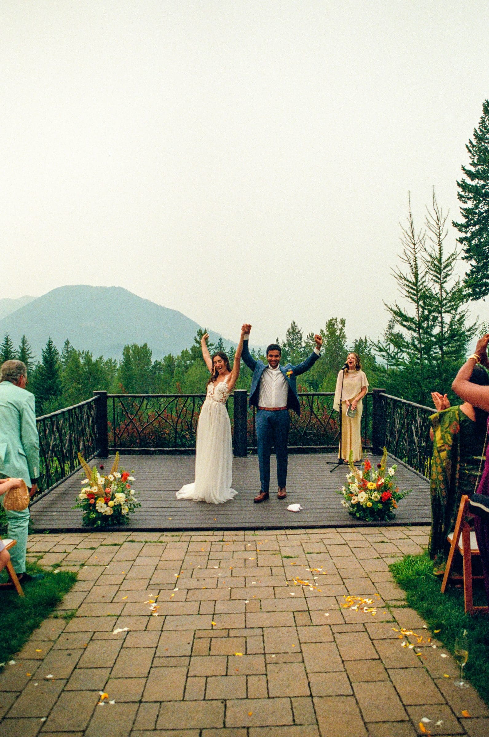 Raj and Isabelle cheering at the end of their ceremony above Lake McDonald, on film