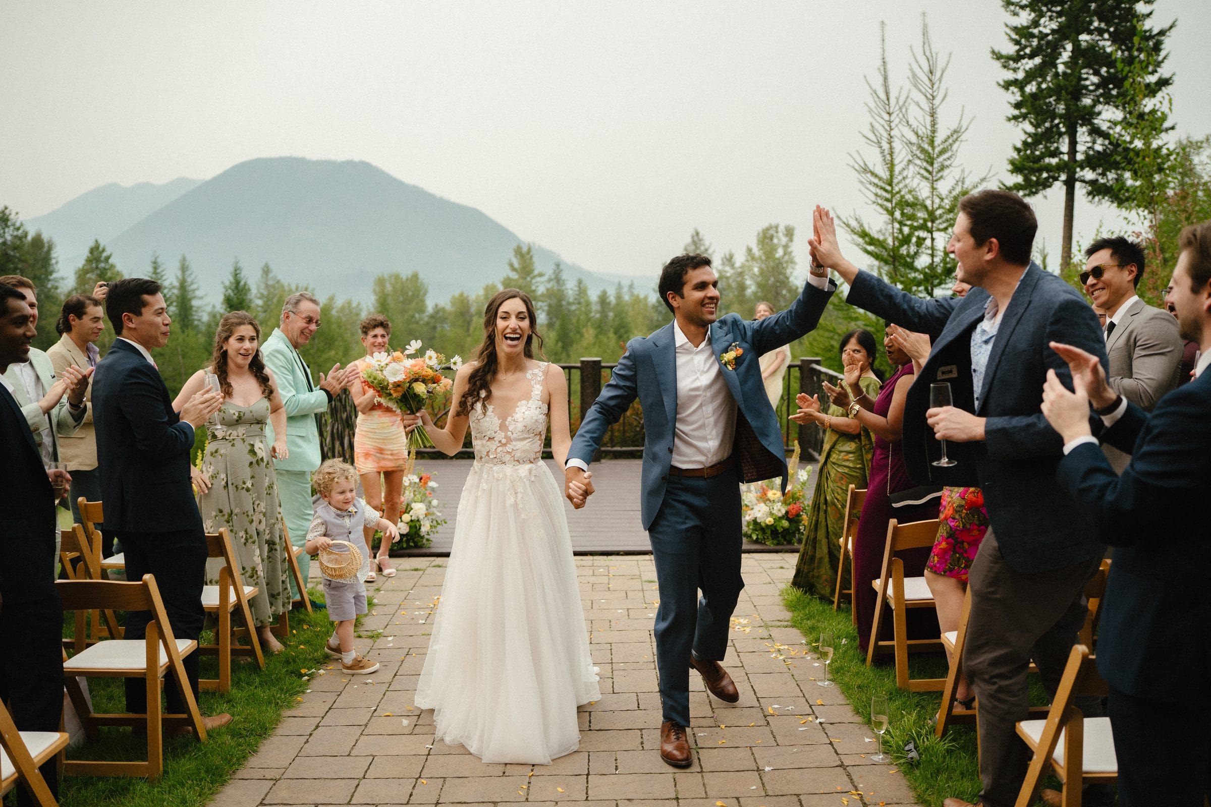 Raj and Isabelle high-fiving guests as they walk back down the aisle