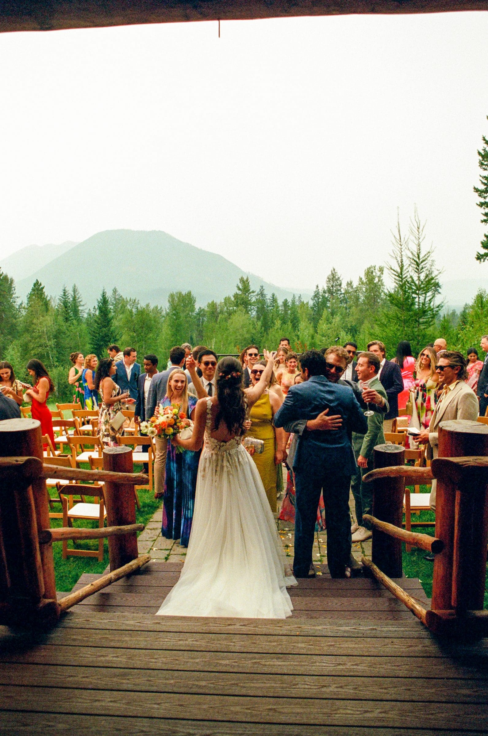 Raj and Isabelle greeting guests after the ceremony with the mountains behind, on film